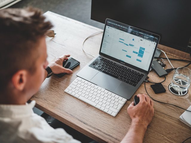 Man achter laptop